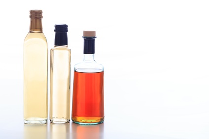 Bottles of vinegar on white background